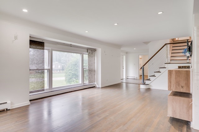 interior space with wood-type flooring and a baseboard heating unit