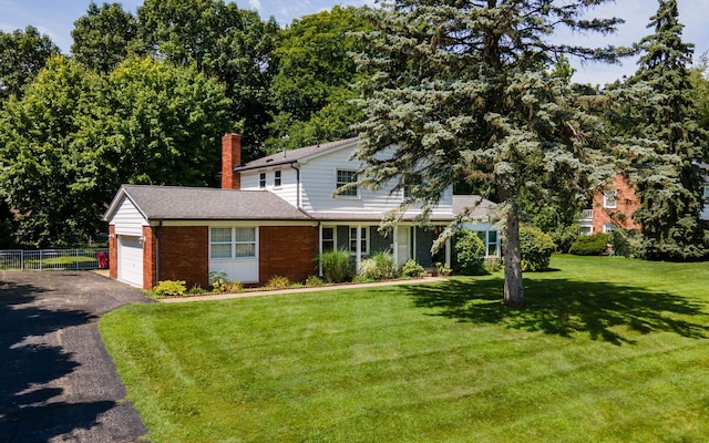 view of front of property featuring a garage and a front lawn