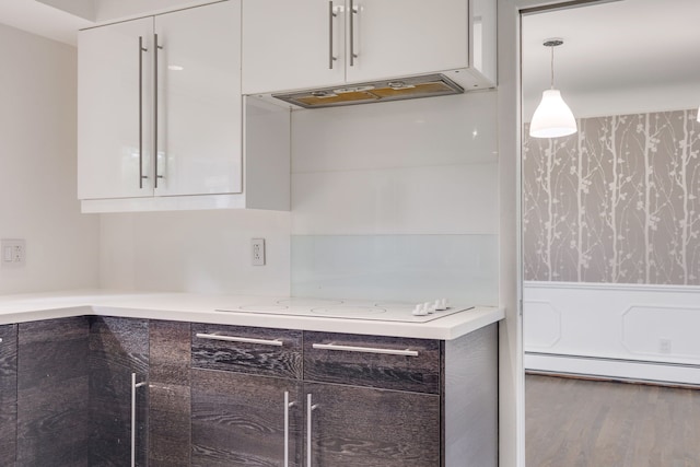 kitchen featuring extractor fan, a baseboard heating unit, wood-type flooring, decorative light fixtures, and white cabinets