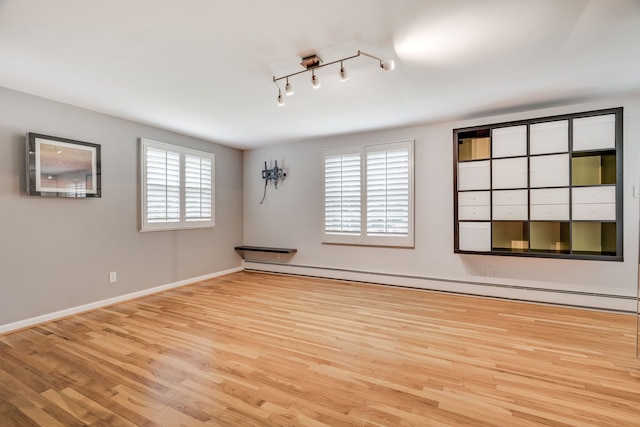 spare room with light wood-type flooring and a baseboard radiator