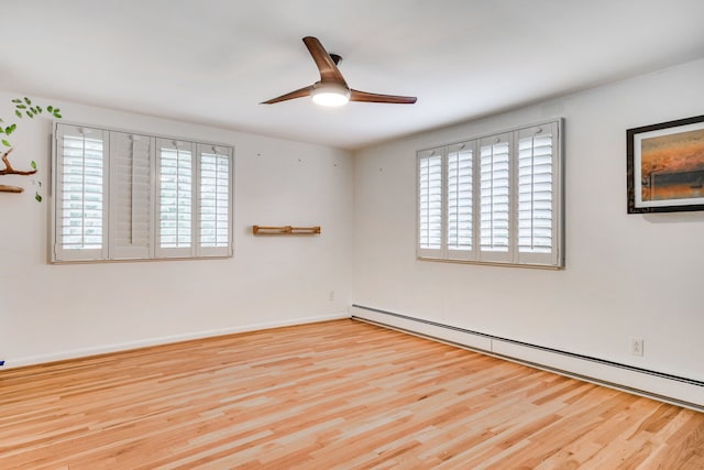 empty room with ceiling fan, light hardwood / wood-style flooring, a wealth of natural light, and a baseboard radiator