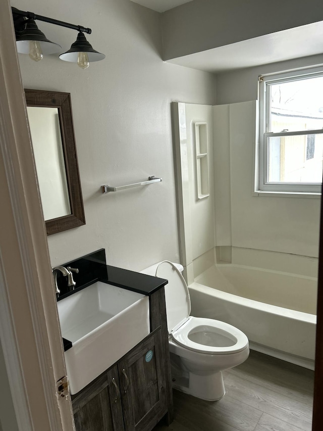 full bathroom featuring shower / bath combination, vanity, hardwood / wood-style flooring, and toilet