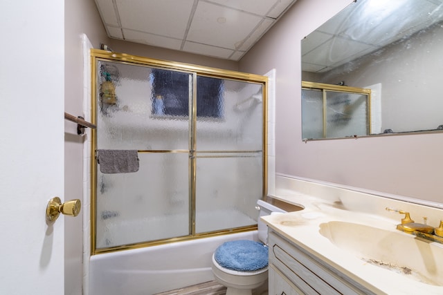 full bathroom with shower / bath combination with glass door, vanity, a paneled ceiling, and toilet