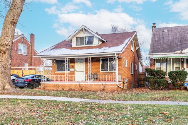 bungalow-style house featuring a porch and a front lawn