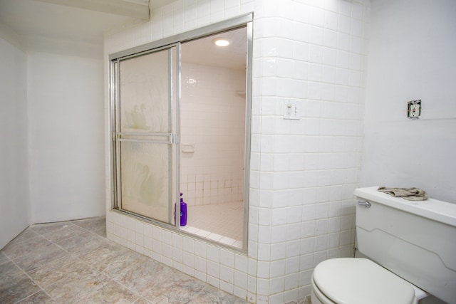 bathroom featuring tiled shower and toilet