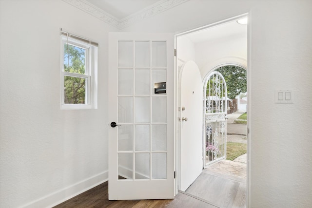 doorway to outside with wood-type flooring and crown molding