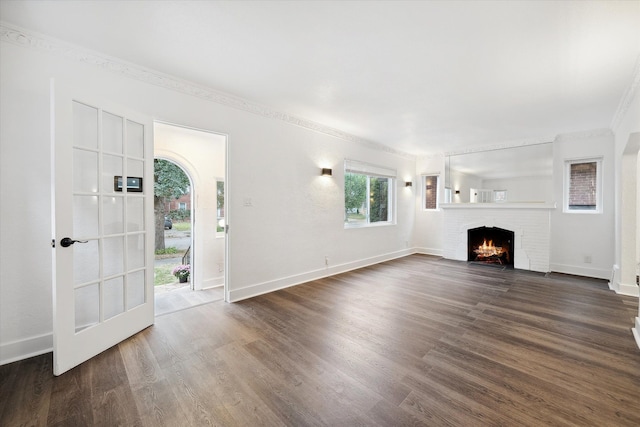 unfurnished living room with a fireplace, dark hardwood / wood-style floors, and ornamental molding