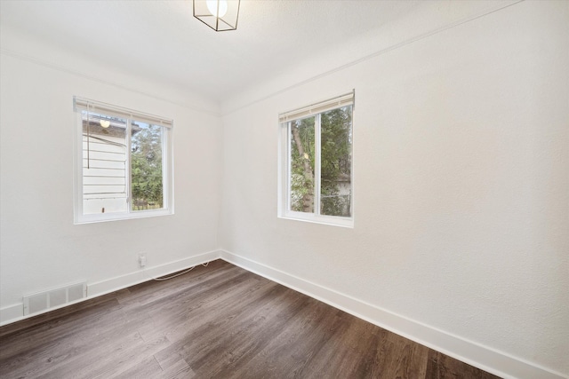 unfurnished room with dark wood-type flooring