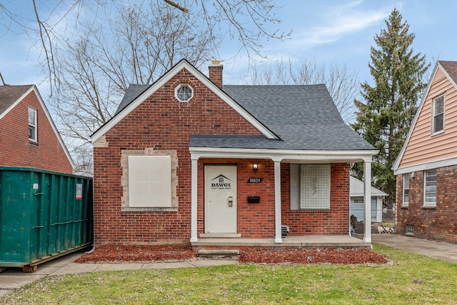 bungalow with a porch and a front lawn