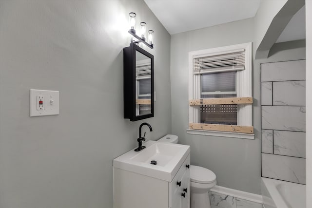 bathroom with vanity, a bathtub, and toilet