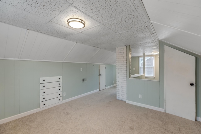 additional living space with light colored carpet and vaulted ceiling