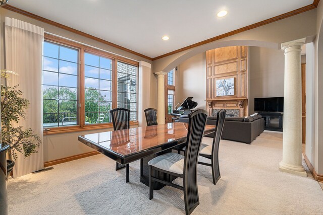 dining area featuring decorative columns, ornamental molding, and light carpet