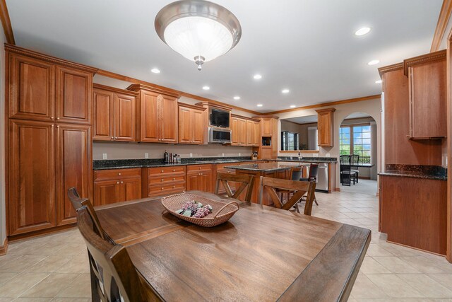 kitchen featuring dark stone countertops, crown molding, and appliances with stainless steel finishes