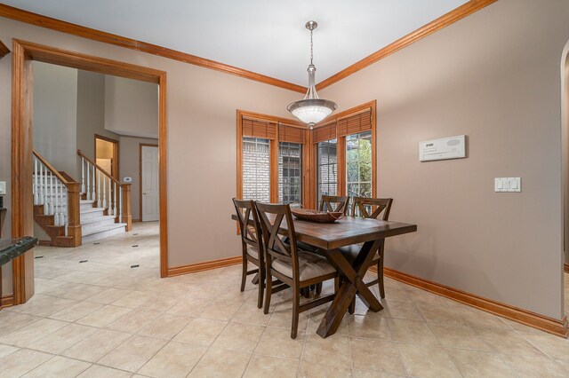 dining space with light tile patterned floors and crown molding