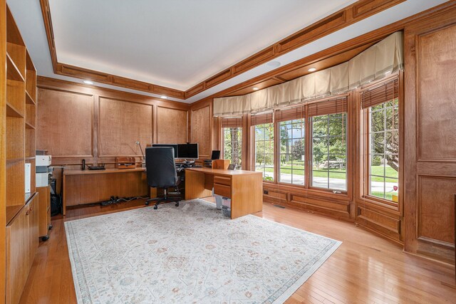 office area featuring light hardwood / wood-style floors, ornamental molding, and wood walls