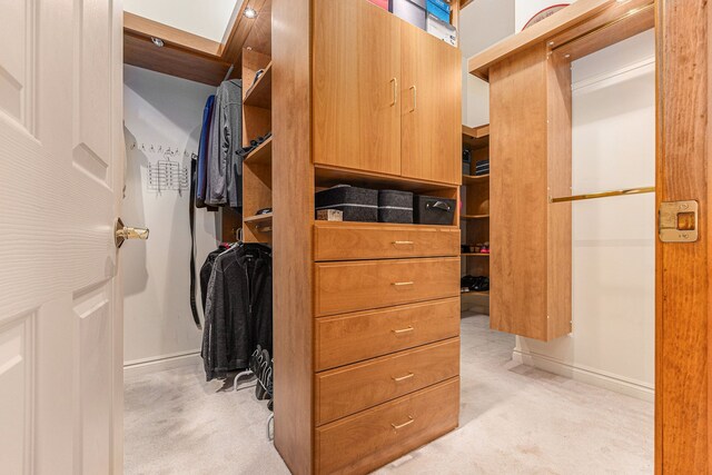 walk in closet featuring light carpet