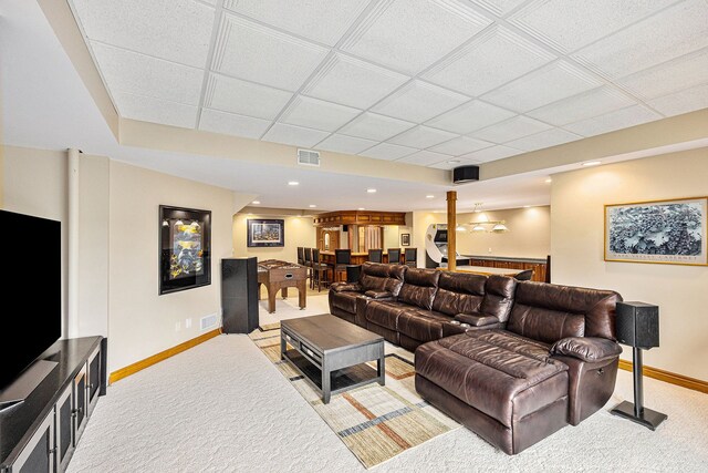 carpeted living room featuring a paneled ceiling