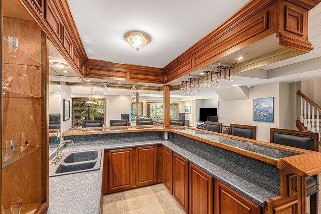 kitchen featuring sink, a raised ceiling, light tile patterned floors, and kitchen peninsula