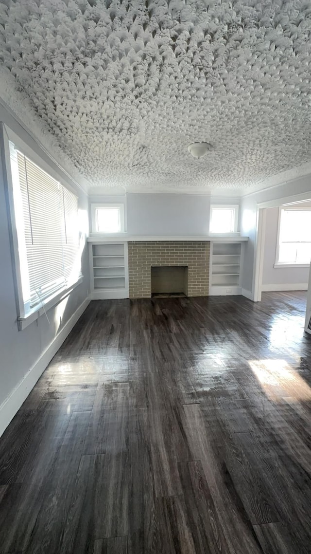 unfurnished living room with a tile fireplace and dark hardwood / wood-style flooring