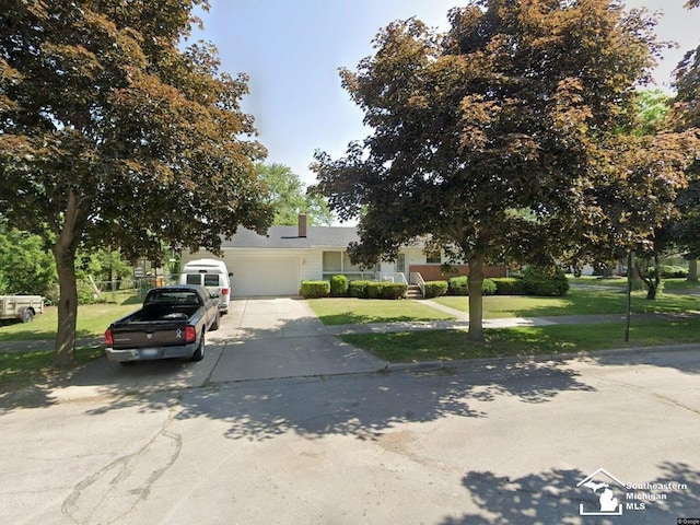 obstructed view of property featuring a garage and a front lawn