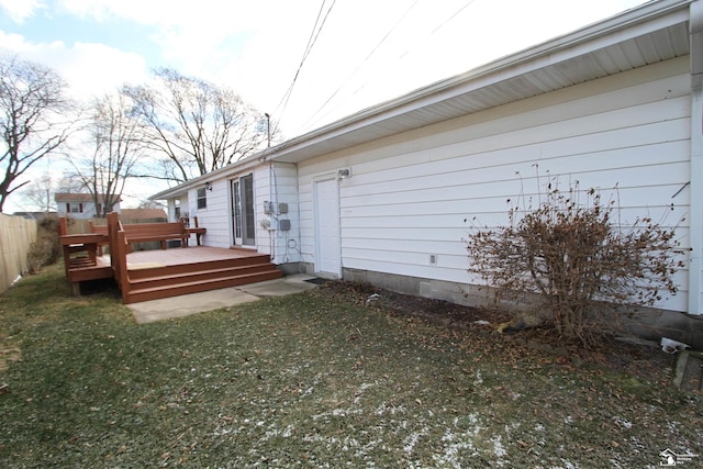 view of side of property with a lawn and a wooden deck