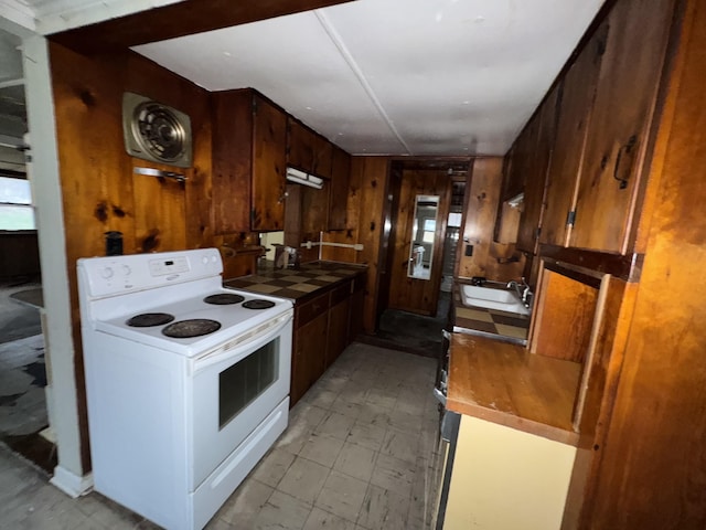 kitchen featuring sink, white electric stove, and wood walls