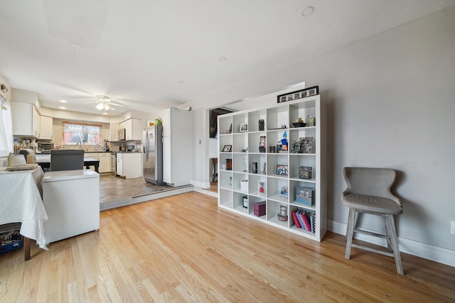 living room featuring light wood-type flooring and ceiling fan