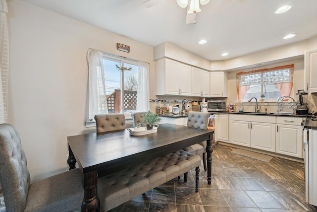 dining space featuring ceiling fan, plenty of natural light, and sink