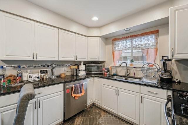 kitchen with dishwasher, stove, dark stone counters, sink, and white cabinetry