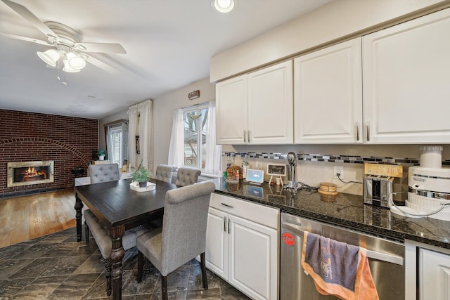 dining area featuring dark hardwood / wood-style floors, ceiling fan, and a brick fireplace