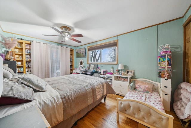 bedroom with hardwood / wood-style flooring, ceiling fan, and crown molding