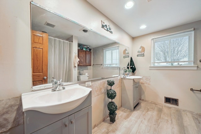 bathroom with hardwood / wood-style flooring, vanity, and toilet