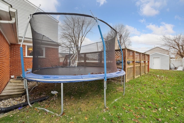 view of yard with a trampoline and a storage unit