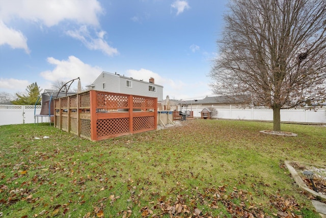 view of yard with a deck and a trampoline