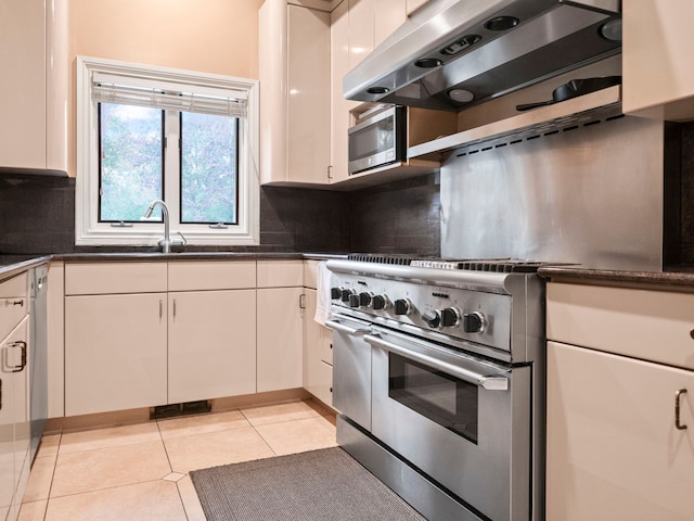 kitchen with ventilation hood, white cabinets, and light tile patterned floors