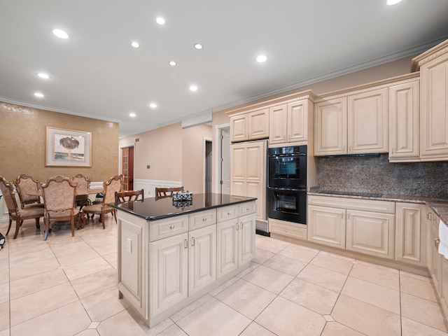 kitchen featuring crown molding, a center island, light tile patterned floors, and black appliances