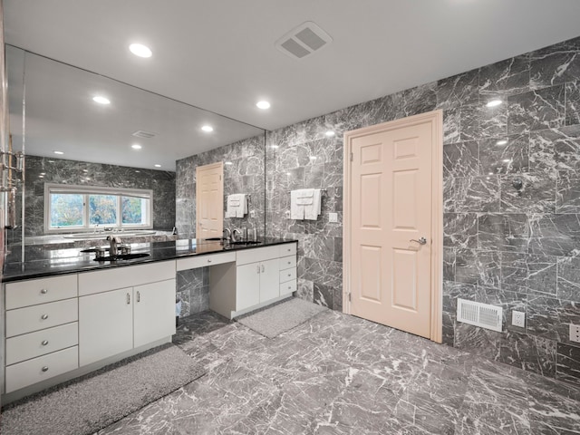 bathroom with vanity and tile walls