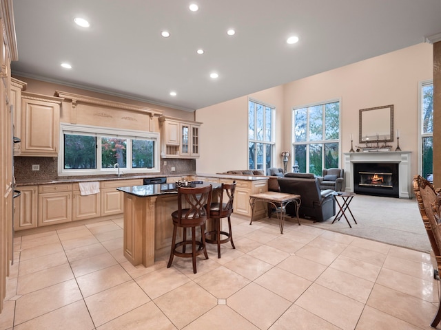 kitchen featuring ornamental molding, light tile patterned floors, tasteful backsplash, a kitchen island, and a breakfast bar area