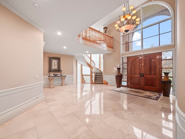 foyer featuring ornamental molding, light tile patterned floors, and a chandelier