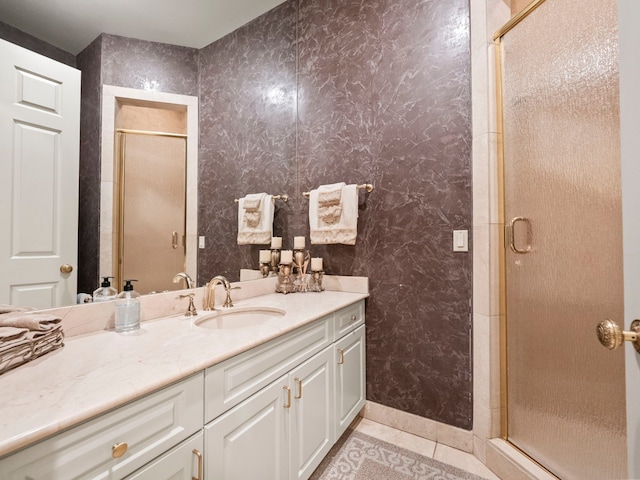 bathroom featuring tile patterned floors, vanity, and a shower with shower door