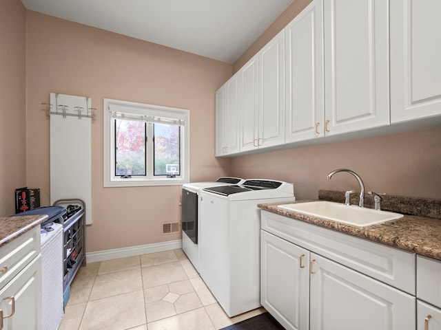 laundry area with cabinets, washing machine and dryer, light tile patterned floors, and sink