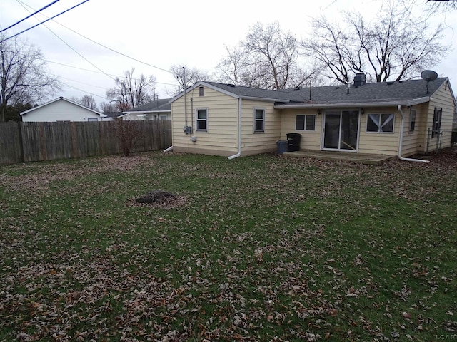 rear view of house featuring a lawn