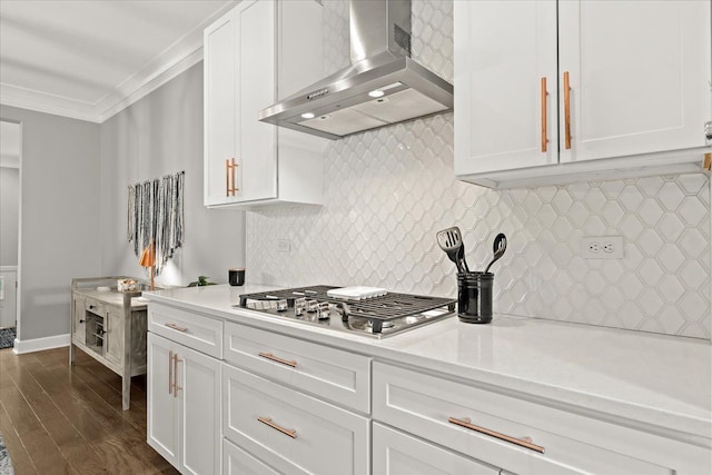 kitchen featuring white cabinets, ornamental molding, stainless steel gas cooktop, and ventilation hood