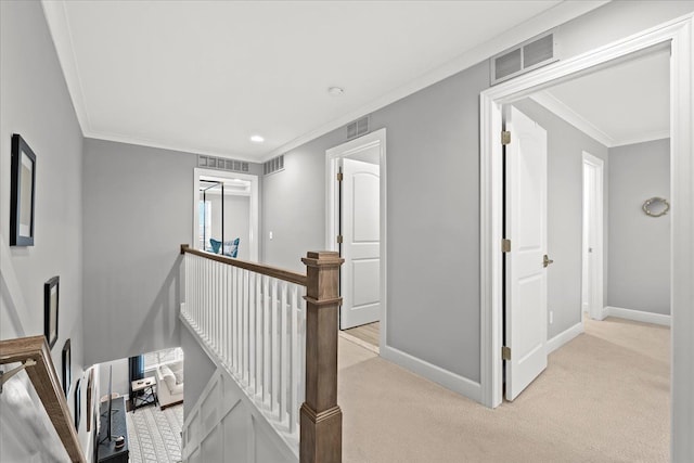 hallway with ornamental molding and light carpet