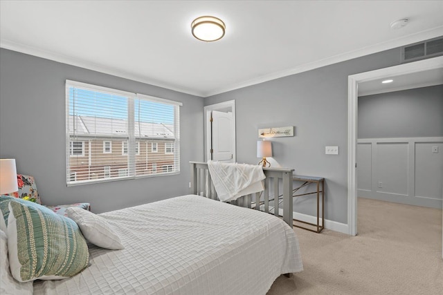 bedroom with ornamental molding and light colored carpet