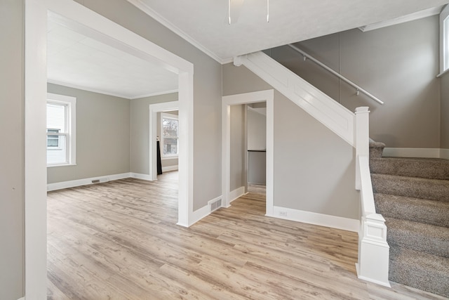 interior space featuring crown molding and light hardwood / wood-style flooring