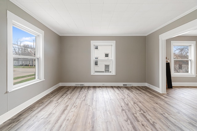 empty room with ornamental molding, light hardwood / wood-style flooring, and a healthy amount of sunlight