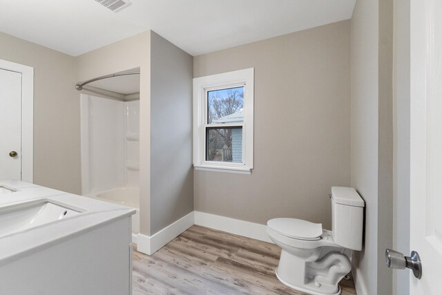 full bathroom with hardwood / wood-style floors, vanity, toilet, and bathtub / shower combination