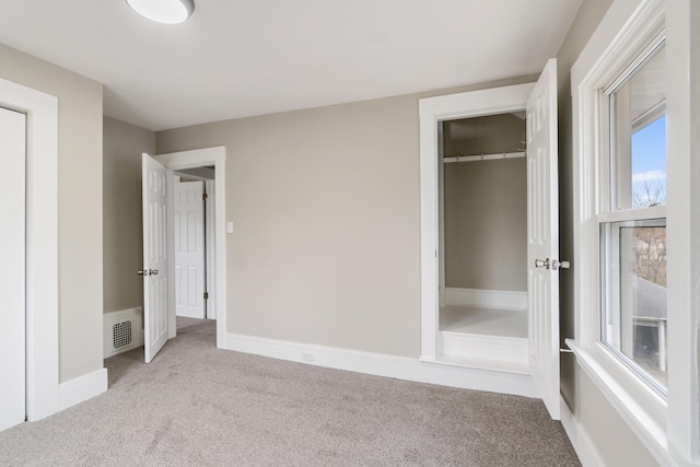 unfurnished bedroom featuring light carpet and a closet