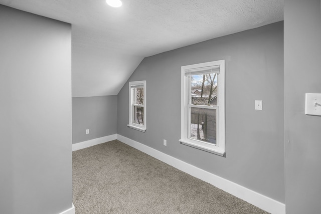 bonus room with carpet flooring, a textured ceiling, and lofted ceiling